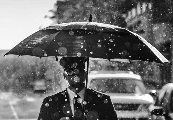 傘をさしたスーツ姿の男性の写真