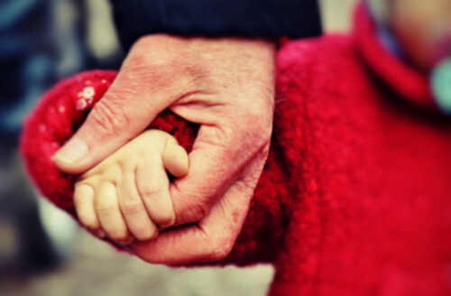 おじいちゃんと孫が手をつないでいる写真